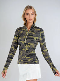 Woman wearing fitted camo print half-zip performance top with gold collar accents, thumbhole sleeves, and silver zipper detail, showcasing the versatile high collar design suitable for athletic and casual wear - front 3/4 view