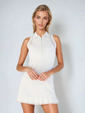 Woman wearing semi-fitted classic dress with silver front zipper, self-fabric collar, and sheer mesh inserts at shoulders and back, showcasing its elegant silhouette and performance features for athletic wear.  Front view.