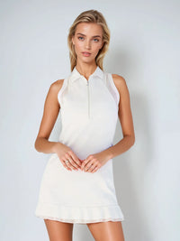 Woman wearing semi-fitted classic dress with silver front zipper, self-fabric collar, and sheer mesh inserts at shoulders and back, showcasing its elegant silhouette and performance features for athletic wear.  Front view.
