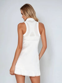 Woman wearing semi-fitted classic dress with silver front zipper, self-fabric collar, and sheer mesh inserts at shoulders and back, showcasing its elegant silhouette and performance features for athletic wear.  Back view.