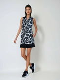 Woman wearing fitted Women's Ultimate Golf Dress with graphic print design, featuring a 17-inch length, front silver zipper, and side pockets, showcasing the tailored silhouette ideal for golf performance and style. Front full view with white background.