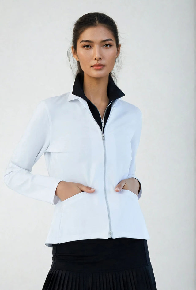 Woman wearing classic-fit Women's Active Blazer in white, showcasing the tailored silhouette with four-way stretch fabric suitable for both professional and active settings.  Front view with hands in pockets.