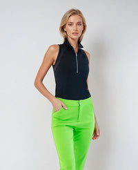 Woman wearing Neisha Classic Sleeveless Polo in black with silver zip and mesh shoulder inserts, demonstrating the semi-fitted design and ventilation features of this moisture-wicking golf shirt | Front view worn with pants.