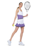 Side view of model wearing the baseline tank in white/lavender combo by inPhorm NYC wearing matching skirt holding a tennis racket and a tennis ball