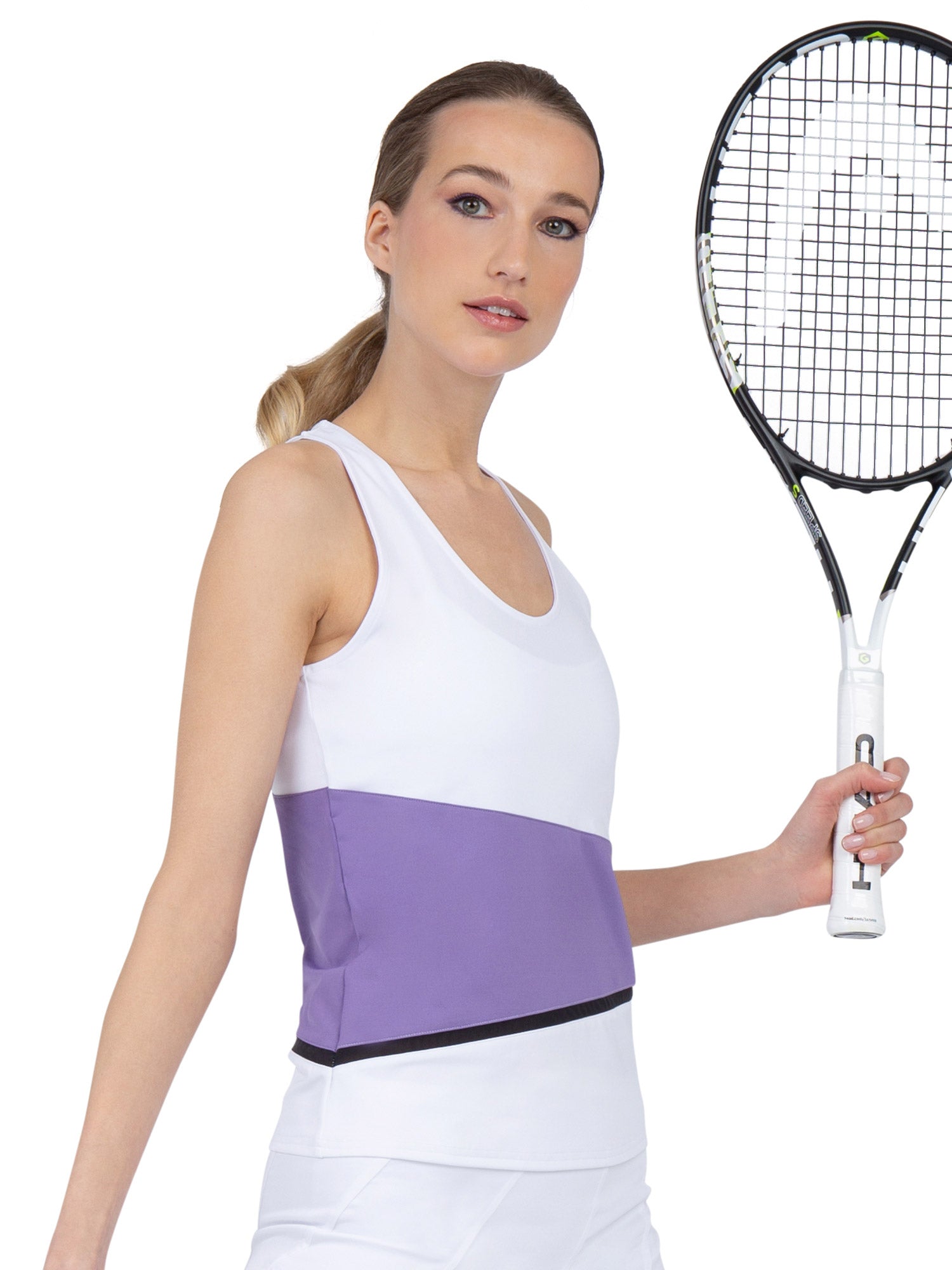 Side view of model wearing the baseline tank in white/lavender combo  by inPhorm NYC one hand at her side and one holding a tennis racket