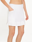 Front view of model wearing the Kai 17" pleated skirt in white by inPhorm NYC with her hand in her pocket