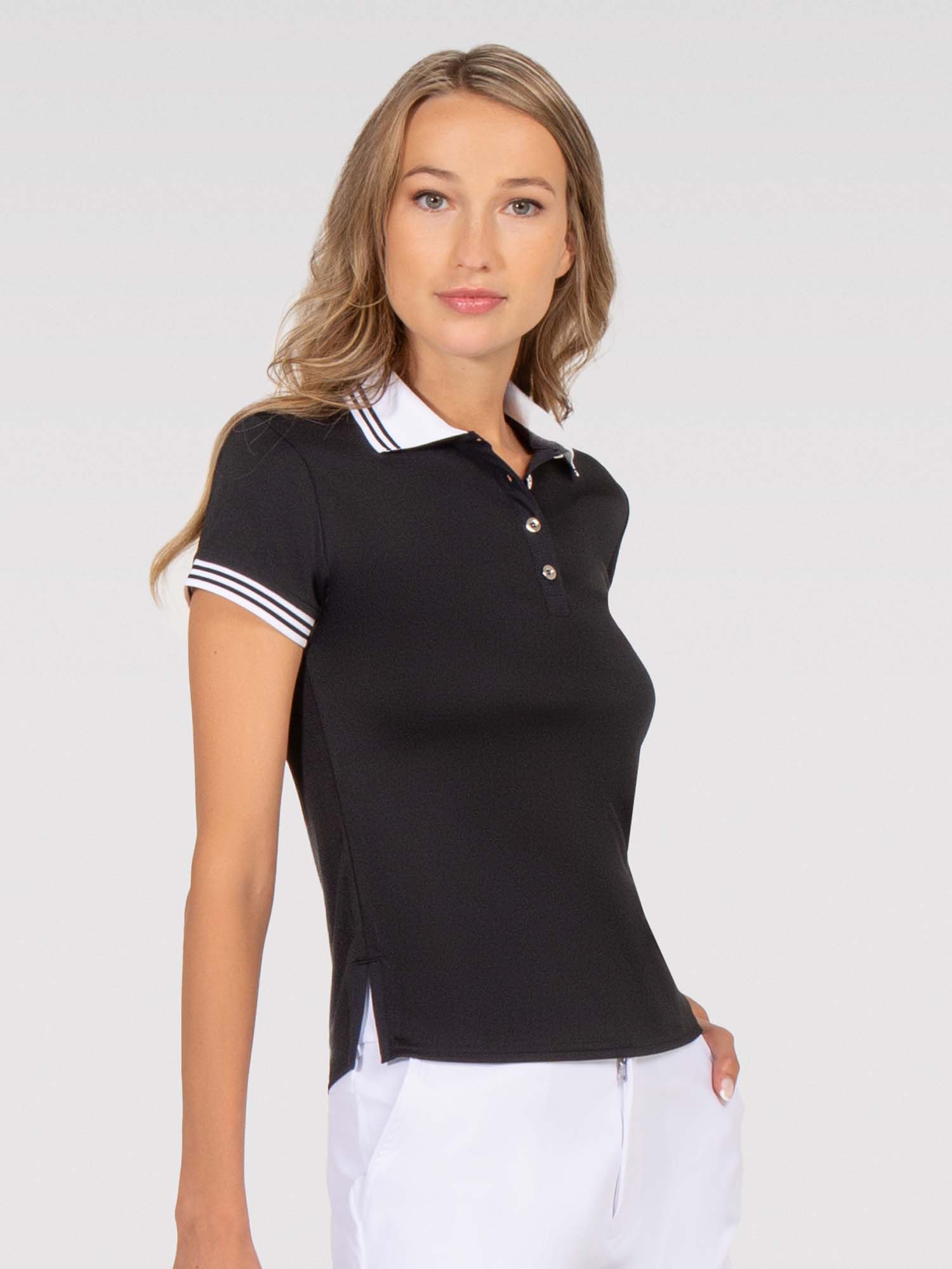 Front view of model wearing the Riley performance short sleeve polo in black and white by inPhorm NYC with one hand in her pocket