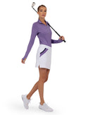 #coFront view of model wearing the Blake 17" golf skirt in white/lavender combo by inPhorm NYC holding a golf club over her shoulderlor_White/Lavender/combo