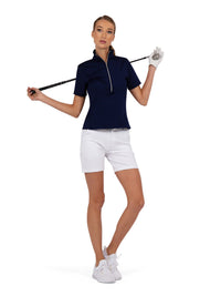 Front view of model wearing the Ivy golf performace short sleeve quarter zip in ink by inPhorm NYC holding a golf club over her shoulders