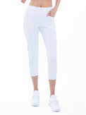 Front view of model wearing the quick dry golf 24" capri pants in white by inPhorm NYC with her hand in her pocket