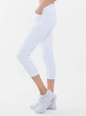 Side view of model wearing the quick dry golf 24" capri pants in white by inPhorm NYC with her hand in her pocket