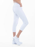 Side view of model wearing the quick dry golf 24" capri pants in white by inPhorm NYC with her hand in her pocket