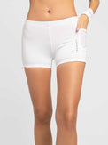 Front view of model wearing the tennis ace shorts in white by inPhorm NYC with her hand in her pocket wearing a wrist band