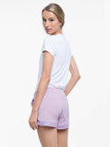 Back view of model wearing the tennis active shorts in lilac by inPhorm NYC with her hands at her side