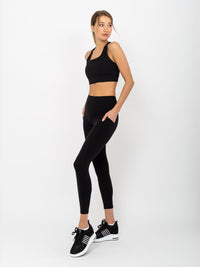 Side view of model wearing the Ashley 7/8 legging in black by inPhorm NYC with hands on her hips