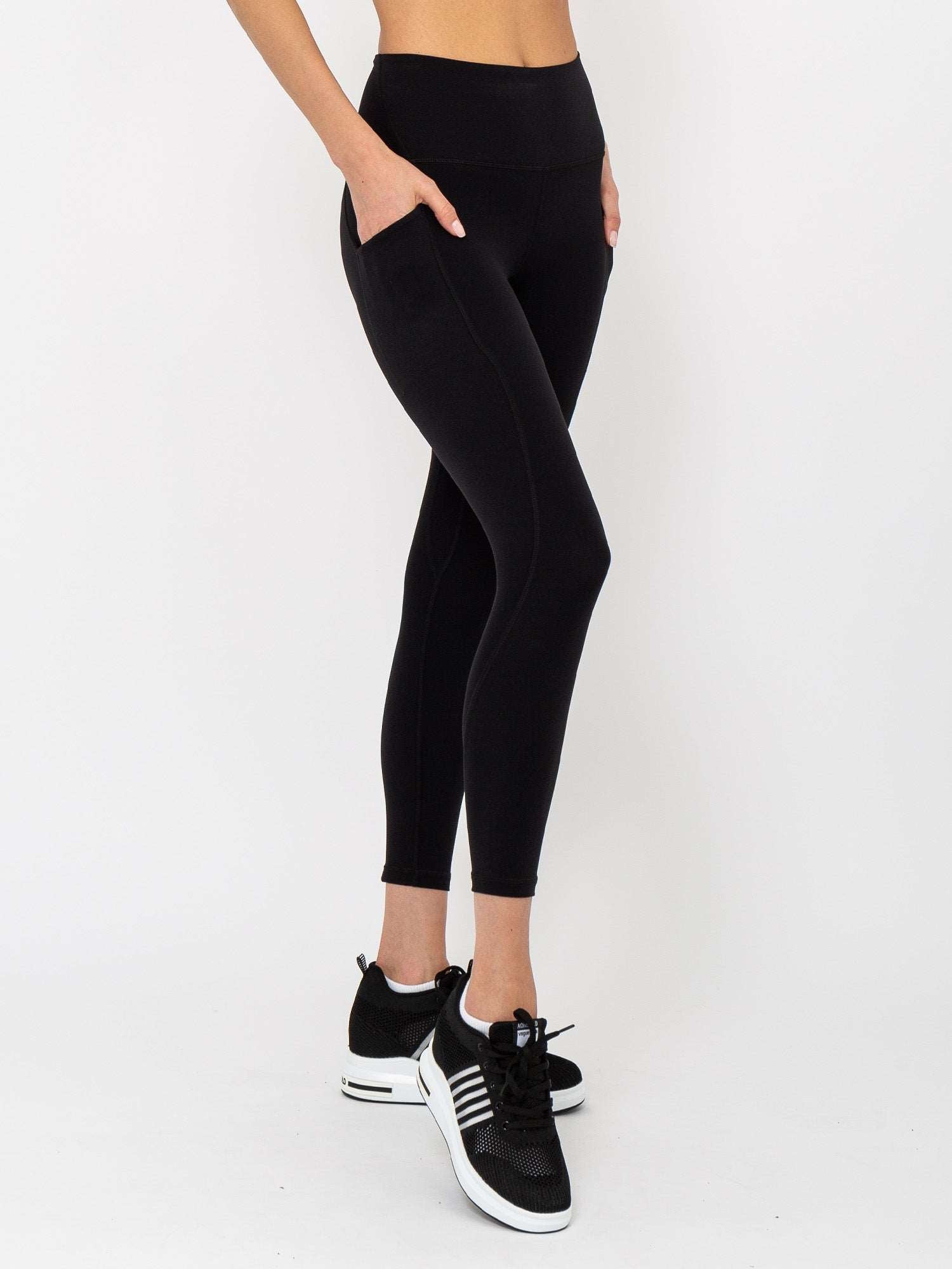 Front view of model wearing the Ashley 7/8 legging in black by inPhorm NYC with one hand in her pocket