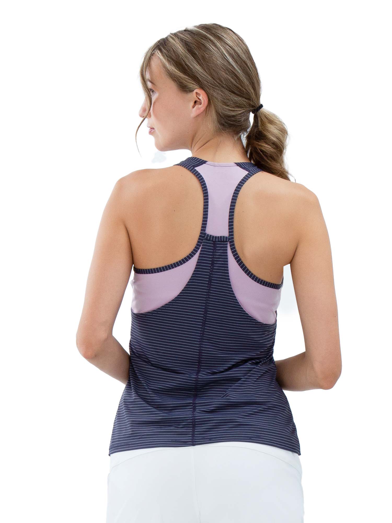 Back view of model wearing the Aubrey double layer athleisure tank in lilac dark shadow by inPhorm NYC with her hands at her waist