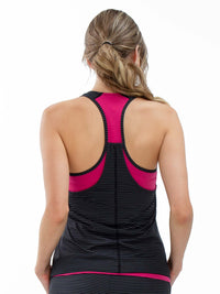 Back view of model wearing the Aubrey double layer athleisure tank in fuchsia and black by inPhorm NYC with her hands at her side