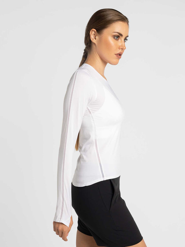 Side view of model wearing the classic long sleeve crew in white by inPhorm NYC with one hand behind her back