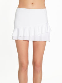 Front view of model wearing the courtside charm tennis skirt in white by inPhorm NYC