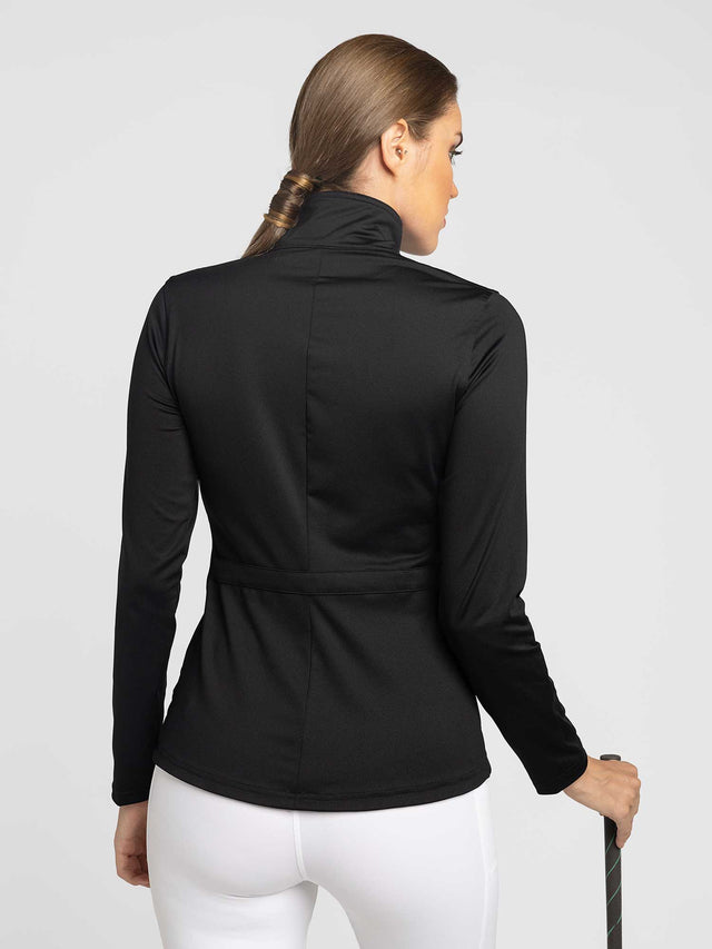 Back view of model wearing the classic blythe jacket in black by inPhorm NYC with her hands at her side holding a golf club