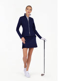 Front view of model wearing the Harlow knit jacket in ink by inPhorm NYC holding a golf club