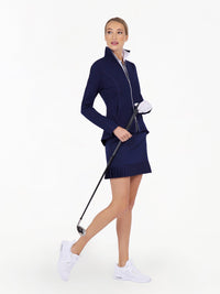 Front view of model wearing the Sinclaire 15" pleated hem golf and tennis skirt in ink by inPhorm NYC wearing mathching skirt holding a golf club