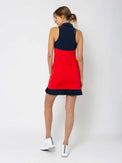 Back view of model wearing the Kai 15" pleated skirt in poppy and midnight by inPhorm NYC with her hands at her side