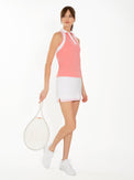 Front side view of model wearing the Lilian 13 1/2" skirt in white and plumeria by inPhorm NYC holding a tennis racket