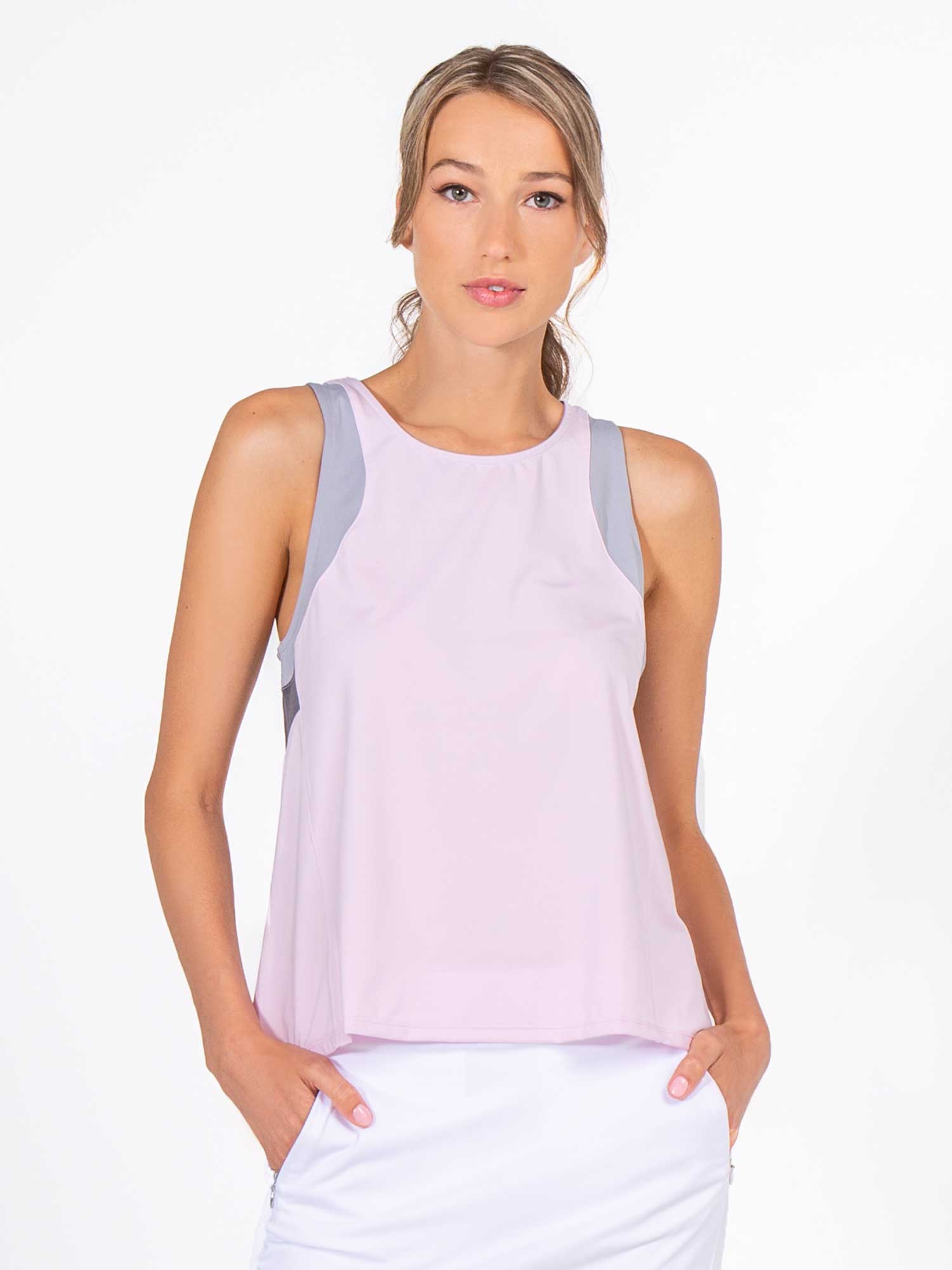 Front view of model wearing the Lilian tennis and active tank in ice pink combo by inPhorm NYC with her hands in her pockets