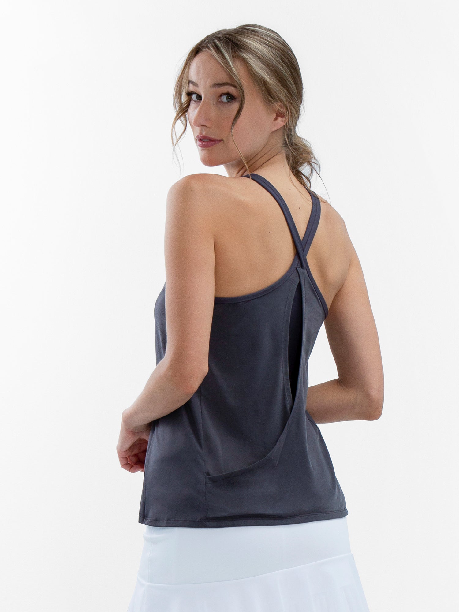 Back view of model wearing the Nora halter neck active and tennis tank in smoke by inPhorm NYC with her arns bent