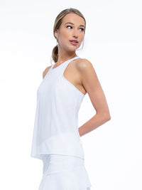 Front side view of model wearing the Nora halter neck active and tennis tank in white by inPhorm NYC with one hand behind her back