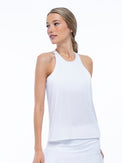 Front view of model wearing the Nora halter neck active and tennis tank in white by inPhorm NYC with her hands at her side