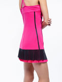 Back view of model wearing the Nora tennis dress in fuchsia and black by inPhorm NYC with her arms crossed