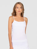 Front view of model wearing the Pearl adjustable strap tank in white by inPhorm NYC with her arms at her side