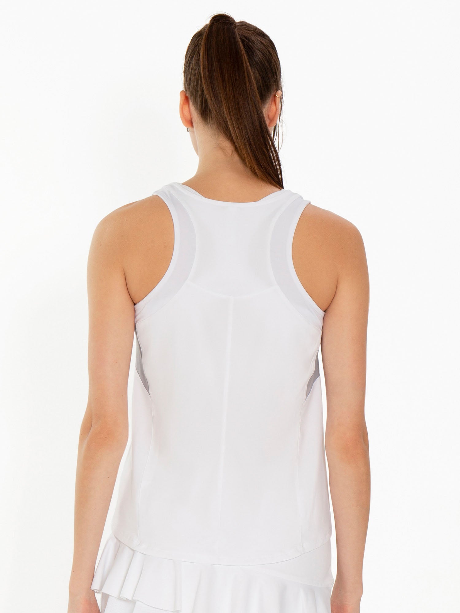 Back view of model wearing the Phoebe tennis and active tank in white and pearl by inPhorm NYC with her hands at her side