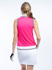 Back view of model wearing the Phoebe sleeveless polo in fuchsia combo by inPhorm NYC wearing a black glove with one hand in her pocket