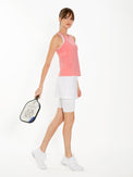 Front side view of model wearing the Ashley performace wrap skort in white by inPhorm NYC holding a tennis racket