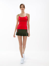 Front view of model wearing the classic 13 1/2" pleated skirt in militare and poppy by inPhorm NYC wearing a red tank top