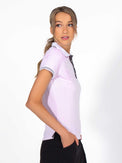 Side view of model wearing the Riley performance short sleeve polo in ice/pink/white/onyx by inPhorm NYC with one hand in her pocket