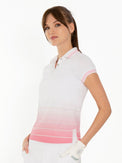 Front view of model wearing the Riley performance short sleeve polo in plumeria ombre by inPhorm NYC wearing a white glove with hands at her hips