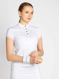 Front view of model wearing the Riley performance short sleeve polo in white and plumeria by inPhorm NYC with her hands at her waist wearing a white wrist band