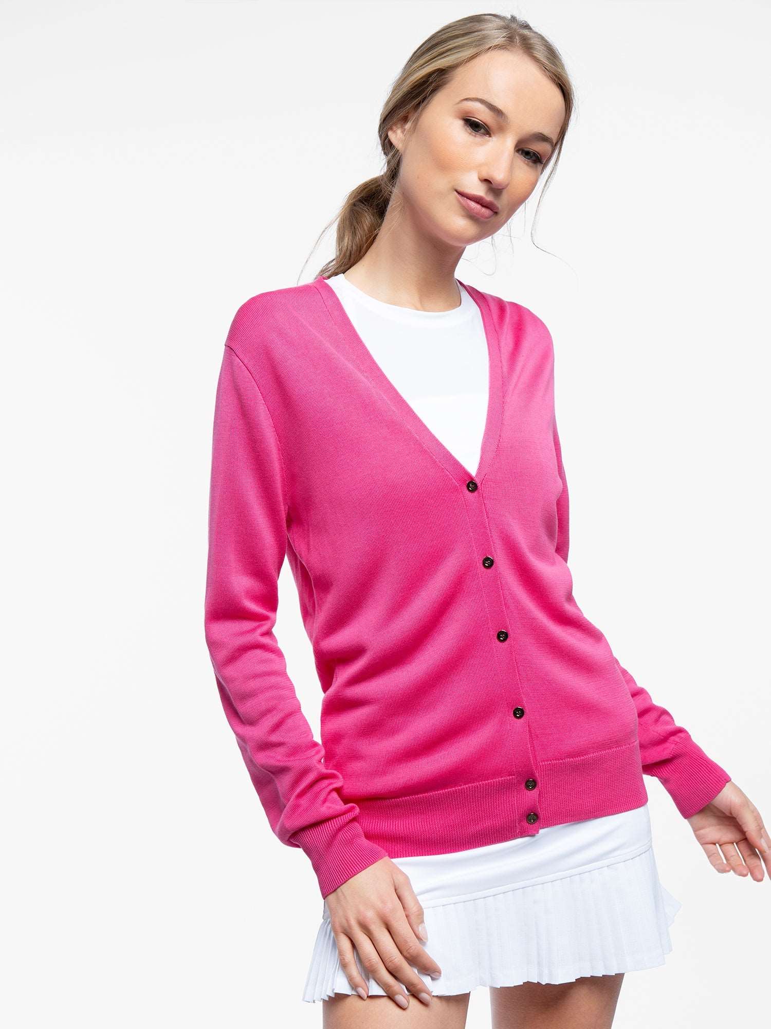 Front view of model wearing the classic cardigan v-neck sweater in pink rose by inPhorm NYC with her hands at her side