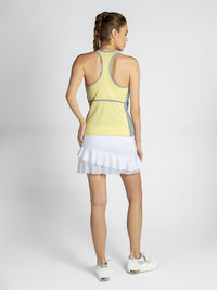 Back view of model wearing the Ashley racer tank in lemondae and pearl by inPhorm NYC with one hand at her hip and one at her side