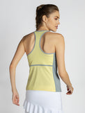 Back view of model wearing the Ashley racer tank in lemondae and pearl by inPhorm NYC wearing a white skirt