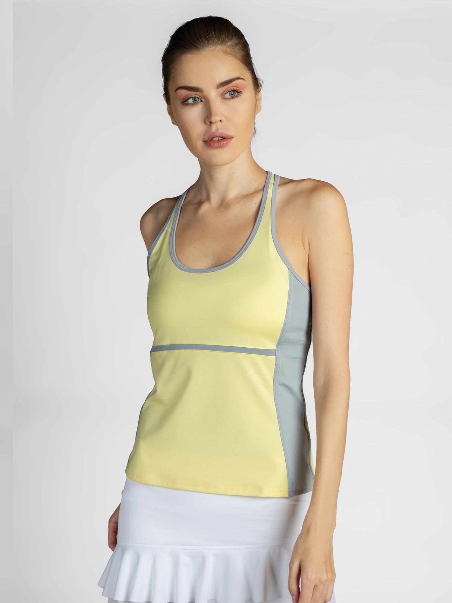 Front view of model wearing the Ashley racer tank in lemondae and pearl by inPhorm NYC with her hands at her side