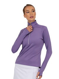 Front view of model wearing the performance zone half zip in lavender by inPhorm NYC with one hand at her side and the other to her zipper